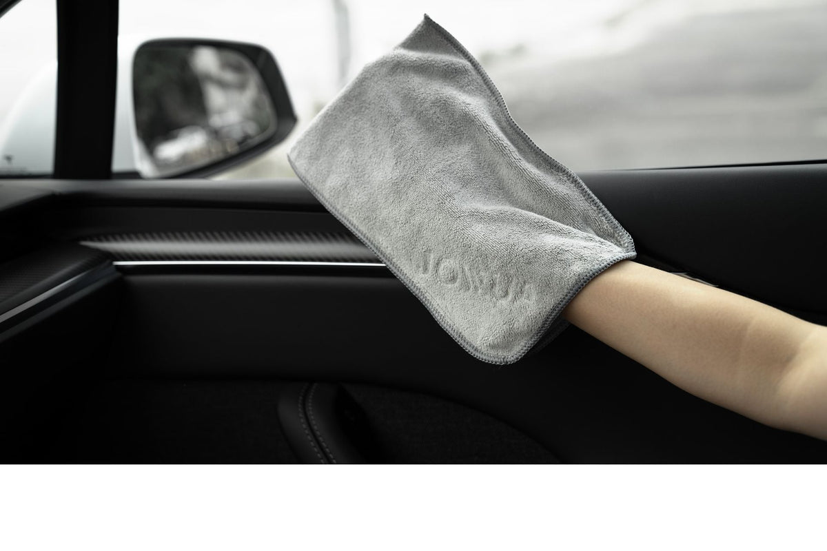 Chiffon en forme de gant enfilé lors du nettoyage du revêtement de porte à l'intérieur du Tesla